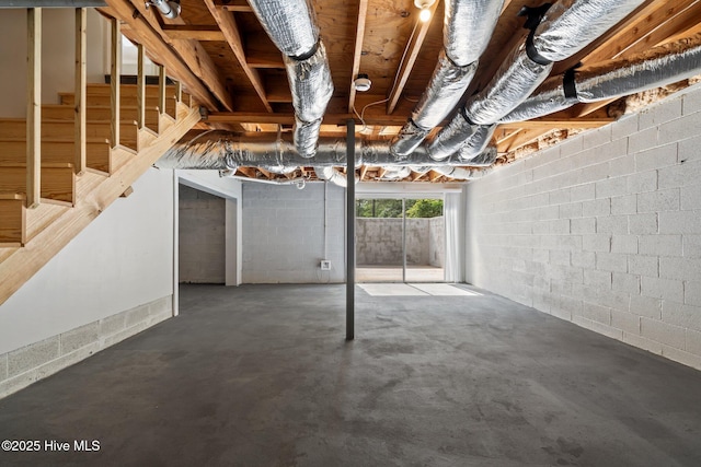 basement with stairs and concrete block wall