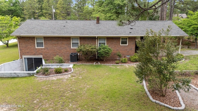 rear view of house with roof with shingles, central air condition unit, and brick siding