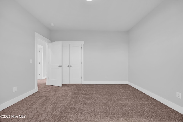 unfurnished bedroom featuring carpet flooring, a closet, and baseboards