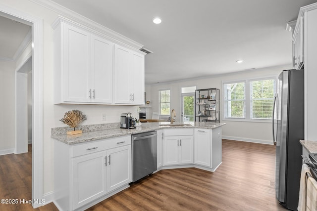 160 Freedom Park Rd, Beaufort, NC 28516 - kitchen with appliances with stainless steel finishes, a sink, dark wood-style flooring, white cabinetry, and a peninsula