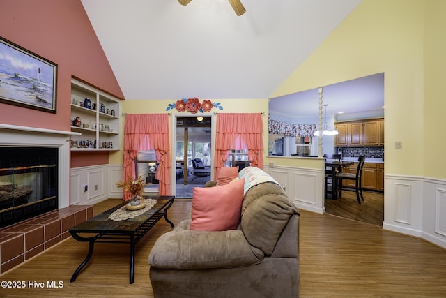 1992 Acorn Dr, New Bern, NC 28562 - living room featuring high vaulted ceiling, wood finished floors, built in shelves, a fireplace, and a wainscoted wall