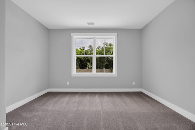spare room with baseboards and carpet