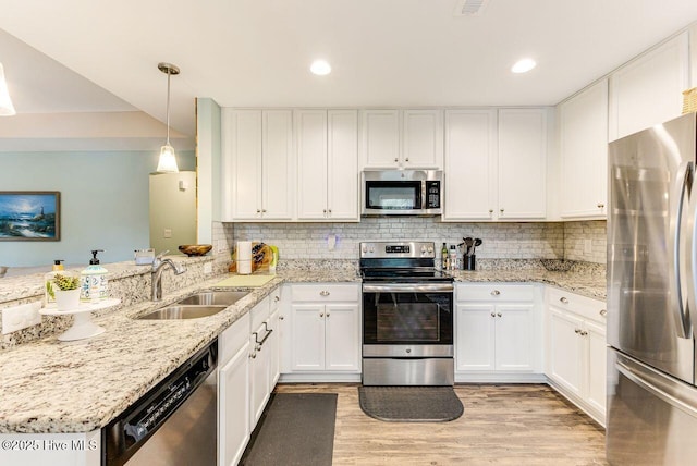 227 NE 38th St, Oak Island, NC 28465 - kitchen featuring stainless steel appliances, white cabinetry, light wood-style flooring, a peninsula, and recessed lighting