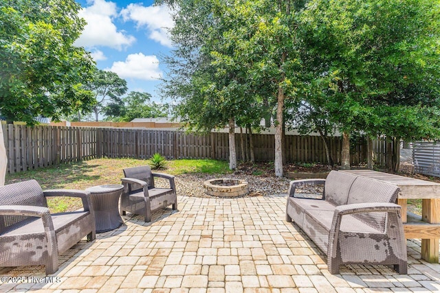 227 NE 38th St, Oak Island, NC 28465 - fenced backyard with a patio area and an outdoor living space with a fire pit