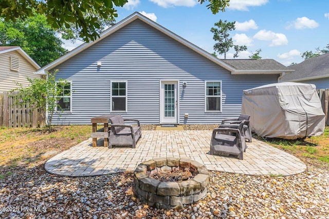 227 NE 38th St, Oak Island, NC 28465 - back of property with a fire pit, a patio area, and roof with shingles