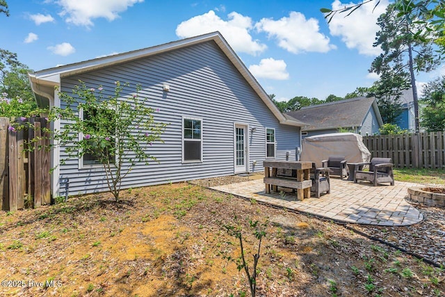 227 NE 38th St, Oak Island, NC 28465 - rear view of property featuring an outdoor fire pit, a patio, and a fenced backyard
