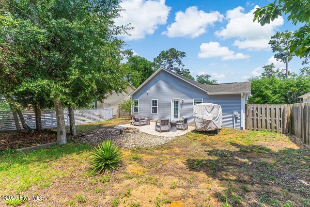 227 NE 38th St, Oak Island, NC 28465 - back of house featuring a fenced backyard, a patio, and an outdoor living space with a fire pit