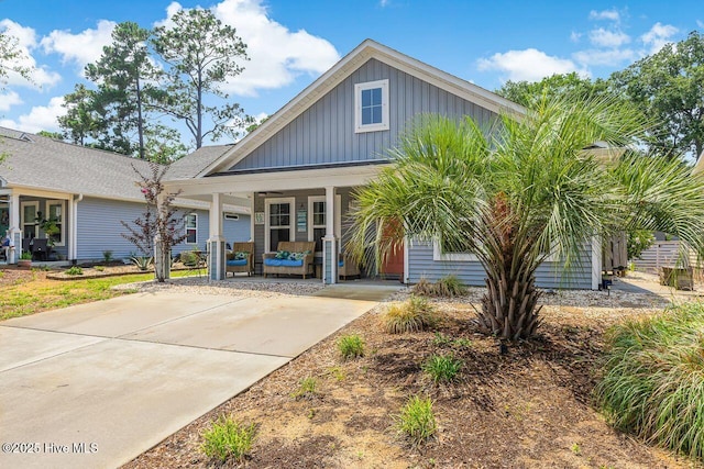 227 NE 38th St, Oak Island, NC 28465 - view of front of home featuring a porch and board and batten siding