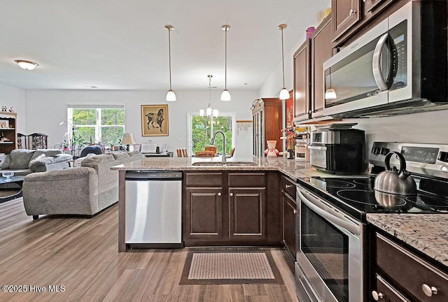 1807 St Patricks Ct SE Lot 267, Bolivia, NC 28422 - kitchen featuring appliances with stainless steel finishes, a sink, a peninsula, light wood-type flooring, and dark brown cabinetry