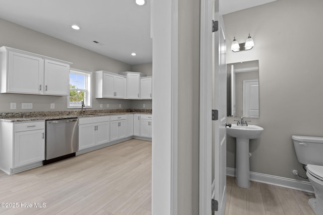 206 Ethan Pl, Hubert, NC 28539 - kitchen featuring dishwasher, white cabinetry, light stone counters, baseboards, and light wood finished floors