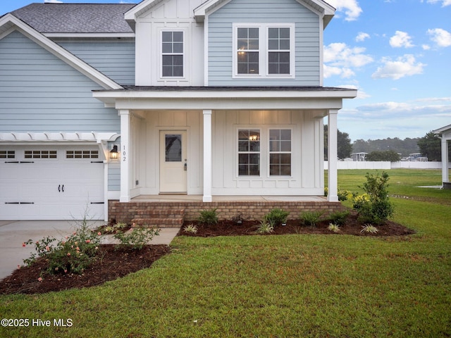 206 Ethan Pl, Hubert, NC 28539 - view of front of home with board and batten siding, covered porch, a garage, roof with shingles, and a front lawn