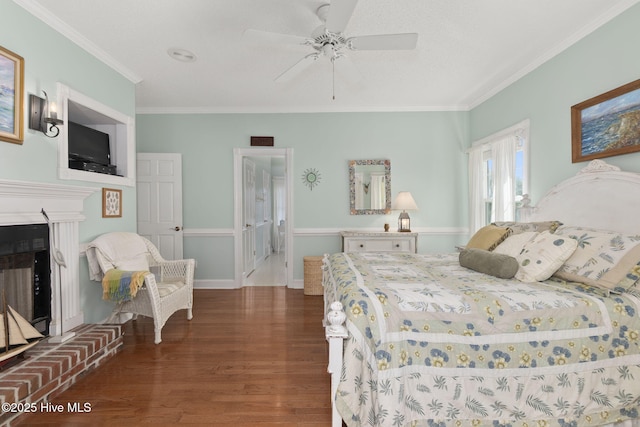 109 Lobster Ln, Emerald Isle, NC 28594 - bedroom featuring wood finished floors, ornamental molding, a fireplace with raised hearth, and a ceiling fan