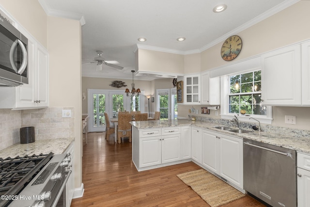109 Lobster Ln, Emerald Isle, NC 28594 - kitchen featuring stainless steel appliances, a peninsula, ornamental molding, light wood finished floors, and ceiling fan
