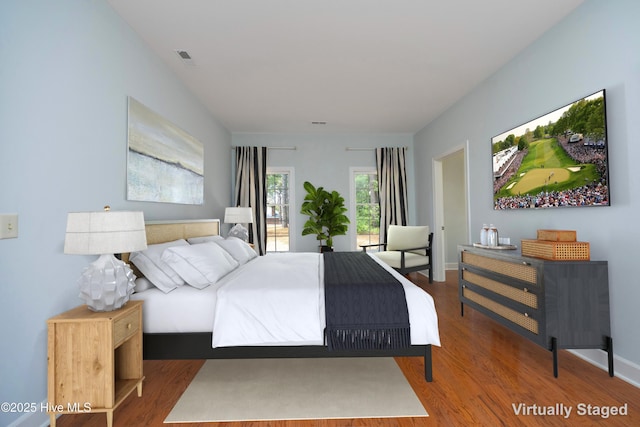 bedroom with wood finished floors and baseboards