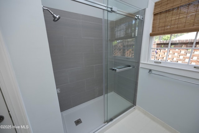 full bathroom with a stall shower and baseboards