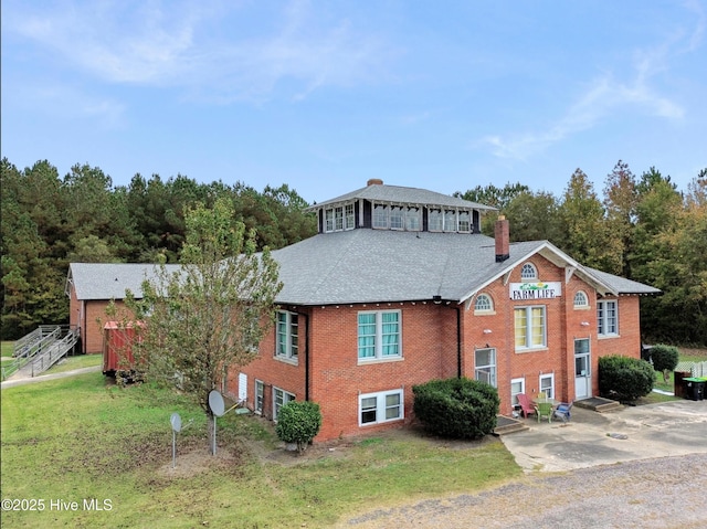 9291 NC-171, Williamston, NC 27892 - view of front of home featuring a chimney, brick siding, a front lawn, and a shingled roof