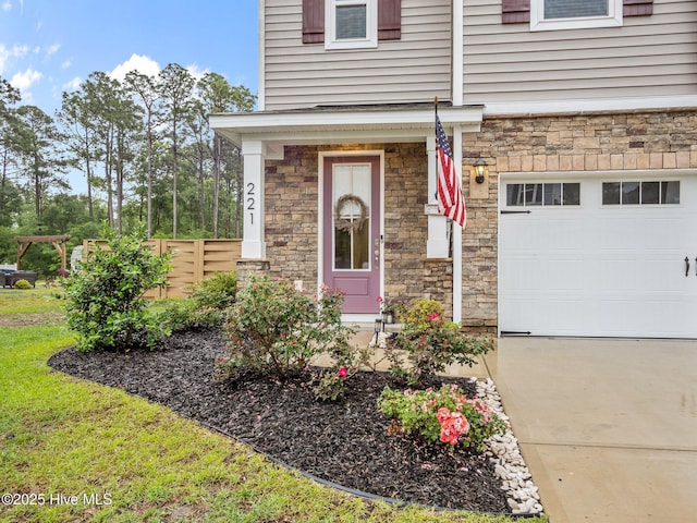 221 Salt Meadow Ln, Newport, NC 28570 - property entrance with stone siding, fence, an attached garage, and driveway