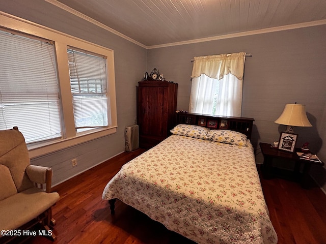 bedroom featuring radiator, crown molding, dark wood-type flooring, and baseboards