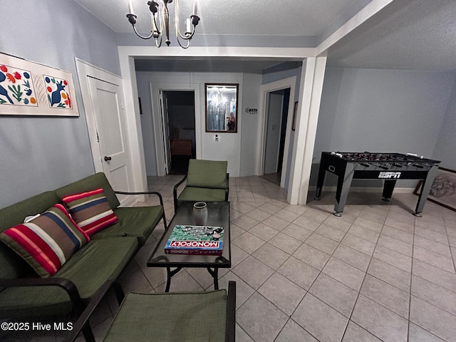 living area featuring a chandelier, light tile patterned flooring, and a textured ceiling