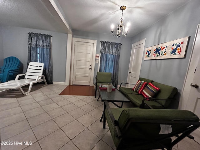 sitting room featuring a chandelier, light tile patterned flooring, a textured ceiling, and baseboards