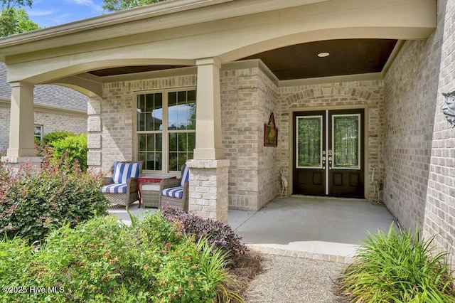697 Jenoa Loop, Castle Hayne, NC 28429 - property entrance featuring covered porch, brick siding, and french doors