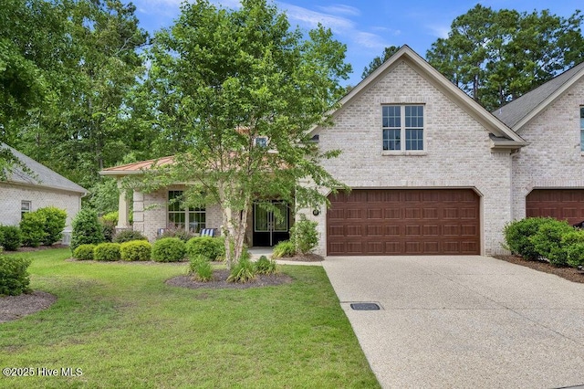 697 Jenoa Loop, Castle Hayne, NC 28429 - view of front of property featuring an attached garage, a front yard, driveway, and brick siding