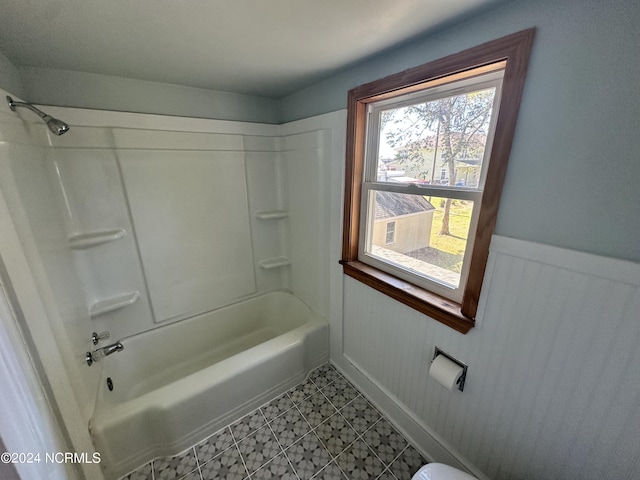 bathroom featuring wainscoting and shower / tub combination