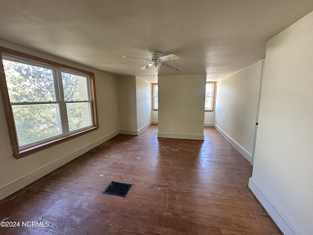 empty room with wood finished floors, baseboards, and ceiling fan