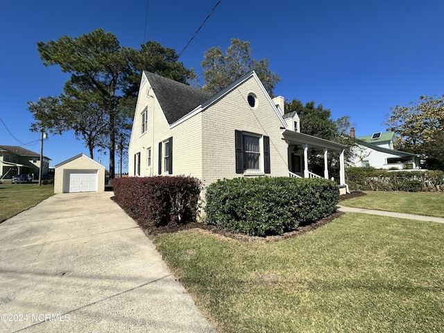 view of home's exterior featuring an outdoor structure, a lawn, a garage, and driveway