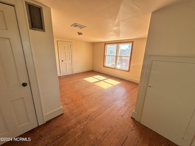 spare room with wood finished floors and baseboards