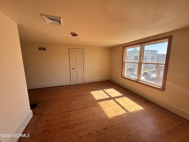spare room with wood finished floors and baseboards