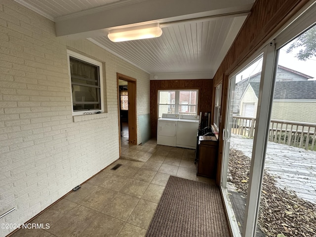 unfurnished sunroom featuring washer and dryer and beam ceiling