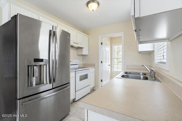 2610 Selkirk Ct, Wilmington, NC 28411 - kitchen with stainless steel refrigerator with ice dispenser, white electric range oven, a sink, white cabinetry, and under cabinet range hood