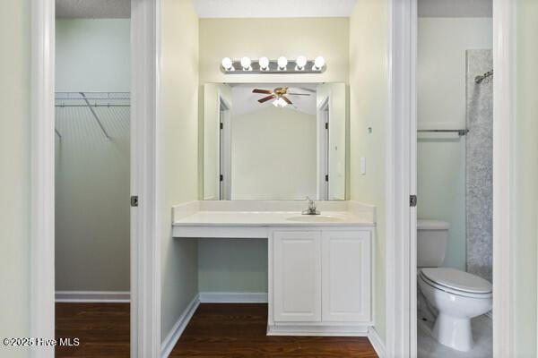 2610 Selkirk Ct, Wilmington, NC 28411 - full bathroom featuring wood finished floors, toilet, a ceiling fan, a walk in closet, and vanity