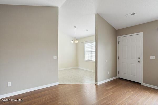 2610 Selkirk Ct, Wilmington, NC 28411 - unfurnished room with wood finished floors, baseboards, and a chandelier