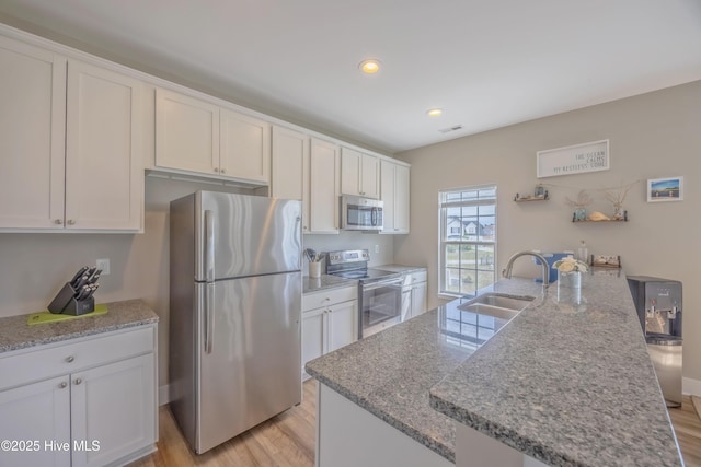 200 Twin Oaks Dr Unit B, Hampstead, NC 28443 - kitchen with appliances with stainless steel finishes, a sink, white cabinetry, light wood-style flooring, and recessed lighting