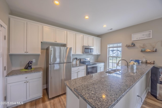 200 Twin Oaks Dr Unit B, Hampstead, NC 28443 - kitchen with stainless steel appliances, a sink, a peninsula, light wood-type flooring, and recessed lighting