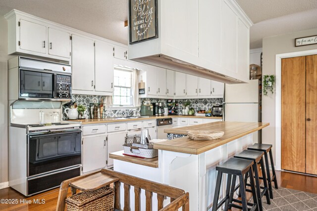 118 Lancashire Ln, West End, NC 27376 - kitchen featuring range with electric stovetop, backsplash, and white cabinets