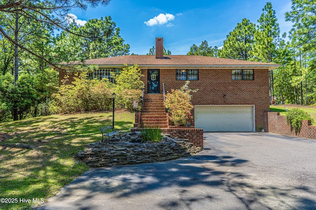 118 Lancashire Ln, West End, NC 27376 - ranch-style home with driveway, a chimney, brick siding, an attached garage, and a front lawn