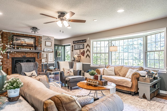 118 Lancashire Ln, West End, NC 27376 - living room with a textured ceiling, a ceiling fan, plenty of natural light, a brick fireplace, and a wainscoted wall