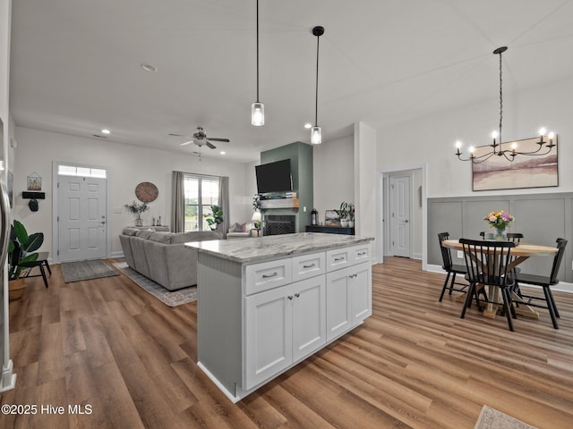 kitchen with a chandelier, wood finished floors, white cabinets, decorative light fixtures, and ceiling fan
