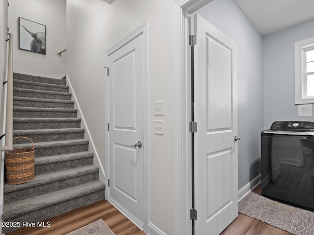 staircase featuring washer / clothes dryer, wood finished floors, and baseboards