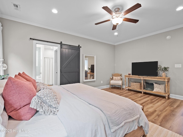 bedroom with crown molding, recessed lighting, wood finished floors, baseboards, and a barn door