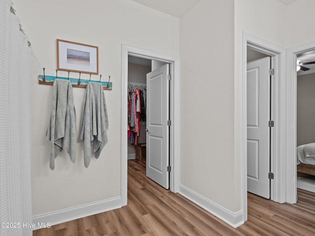 hallway with baseboards and wood finished floors