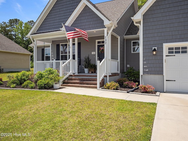 view of front facade with a front yard, a porch, and a shingled roof