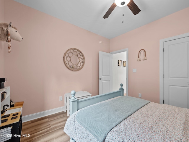 bedroom featuring wood finished floors, baseboards, and a ceiling fan