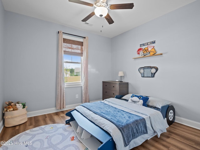 bedroom featuring wood finished floors, baseboards, and a ceiling fan