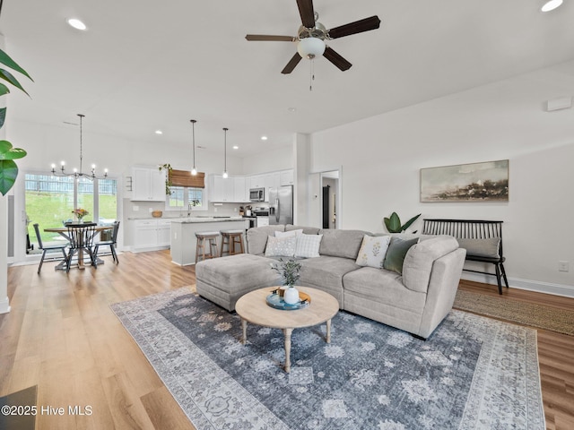 living area featuring a ceiling fan, plenty of natural light, baseboards, light wood-style flooring, and recessed lighting