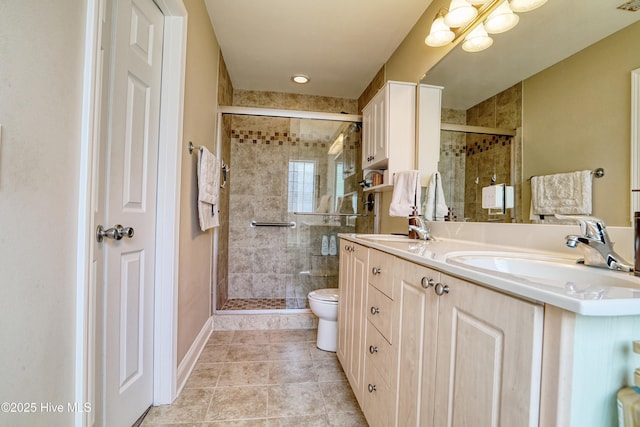 full bathroom featuring a shower stall, tile patterned floors, double vanity, toilet, and baseboards
