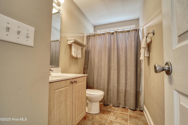 bathroom featuring toilet, vanity, and a shower with curtain